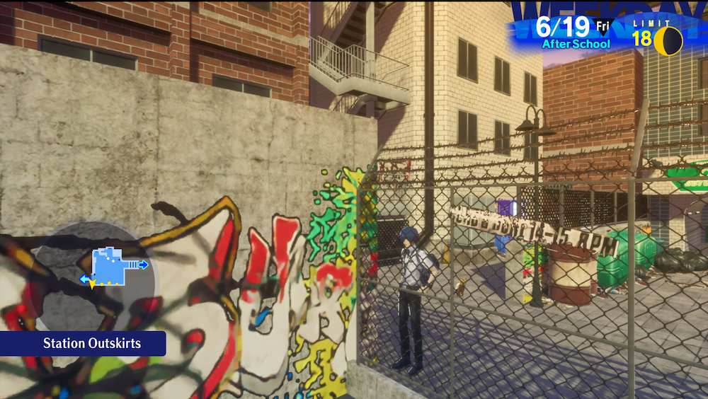 Makoto standing behind a chain link fence in the Station Outskirts and just beyond is a wall of graffiti.